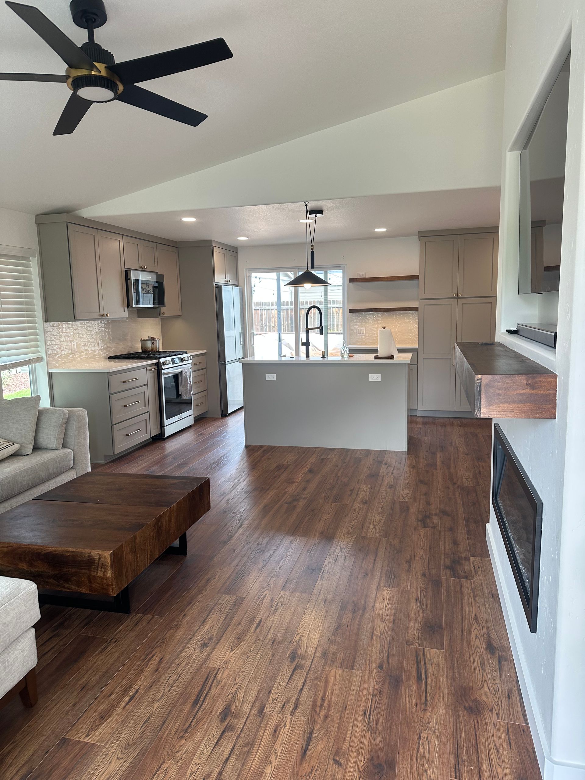 A living room with hardwood floors and a ceiling fan.