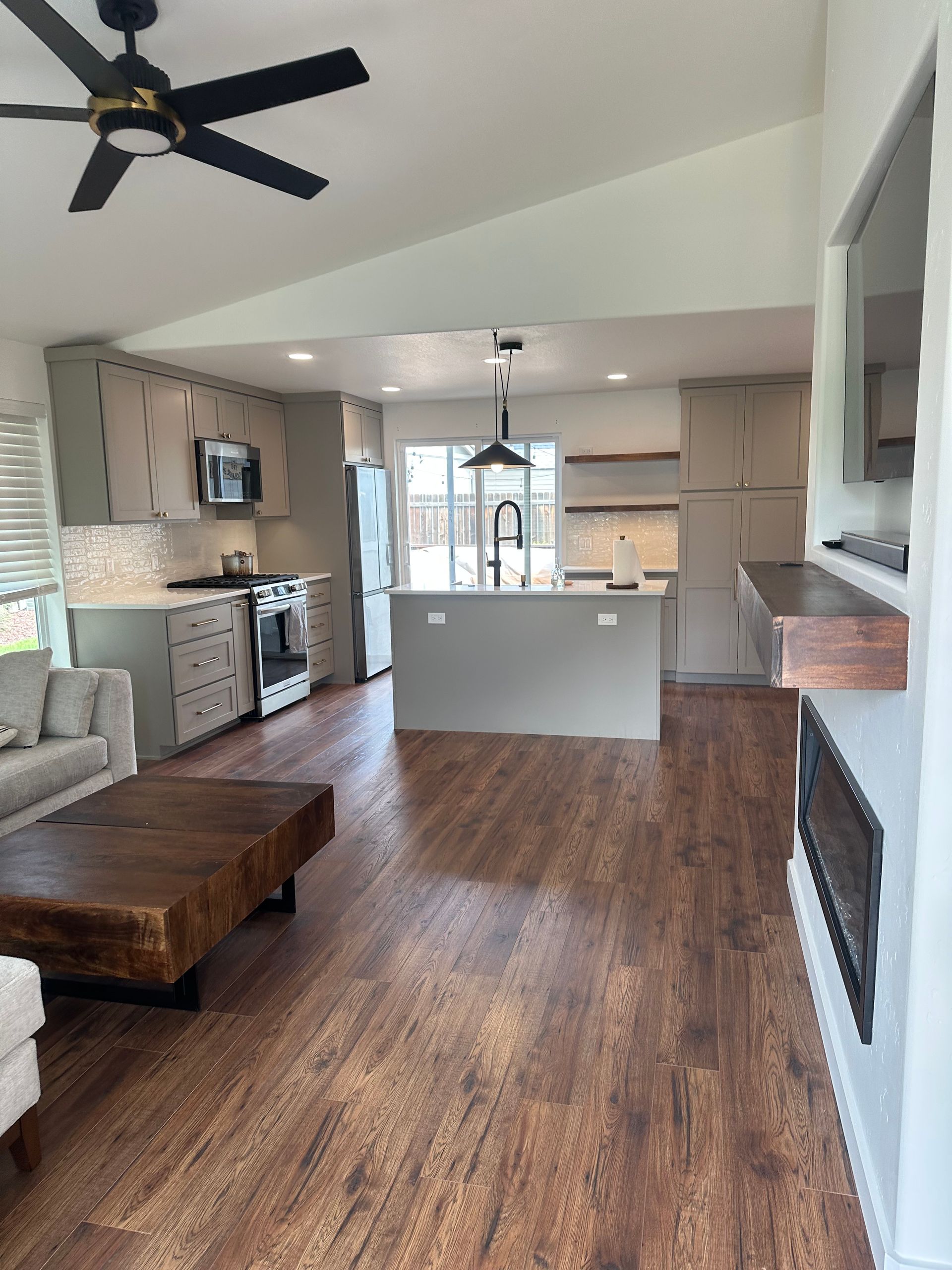 A living room with hardwood floors and a ceiling fan.