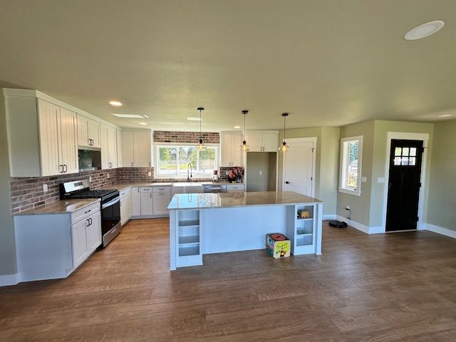 A kitchen with white cabinets and a large island in the middle