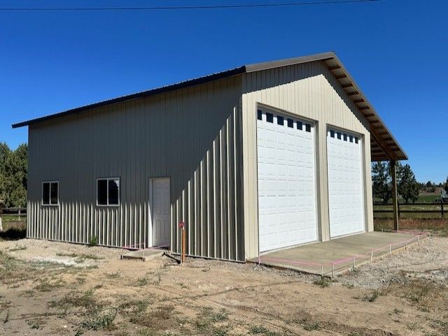 A large metal building with two white garage doors