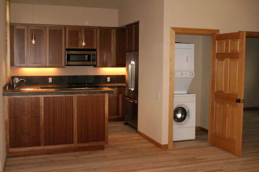 A kitchen with a washer and dryer in the corner