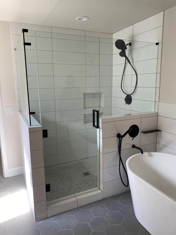 A bathroom with a walk in shower and a bathtub.