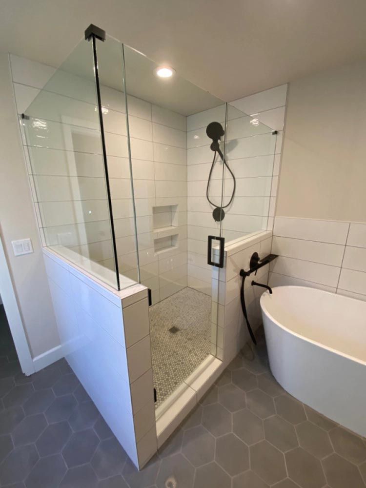 A bathroom with a walk in shower and a bathtub.