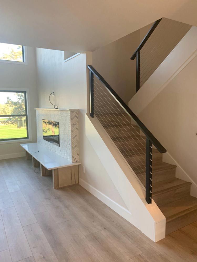 An empty living room with stairs and a fireplace