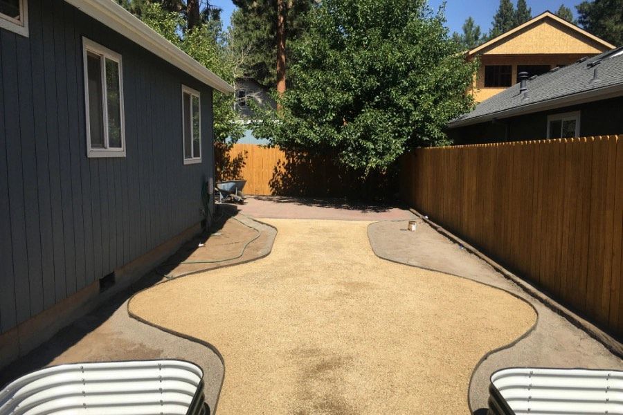 A backyard with a fence and a house in the background.