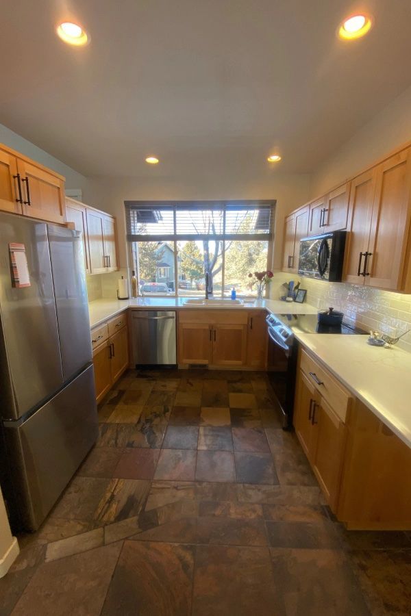 A kitchen with stainless steel appliances and wooden cabinets.