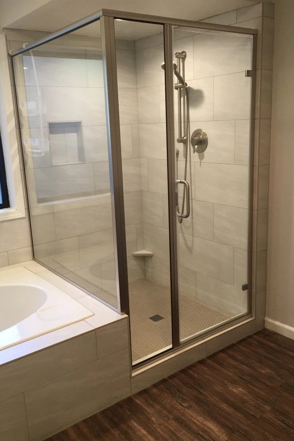 A bathroom with a walk in shower and a bathtub.