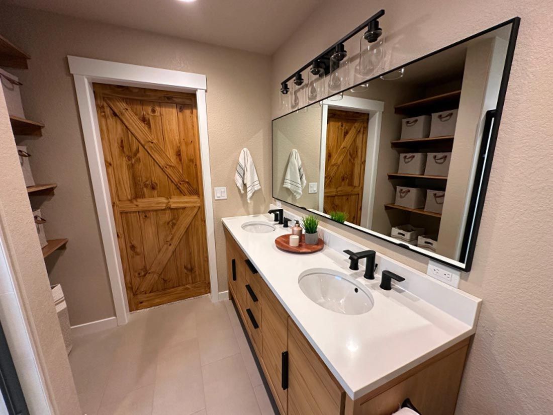 A bathroom with two sinks and a large mirror.