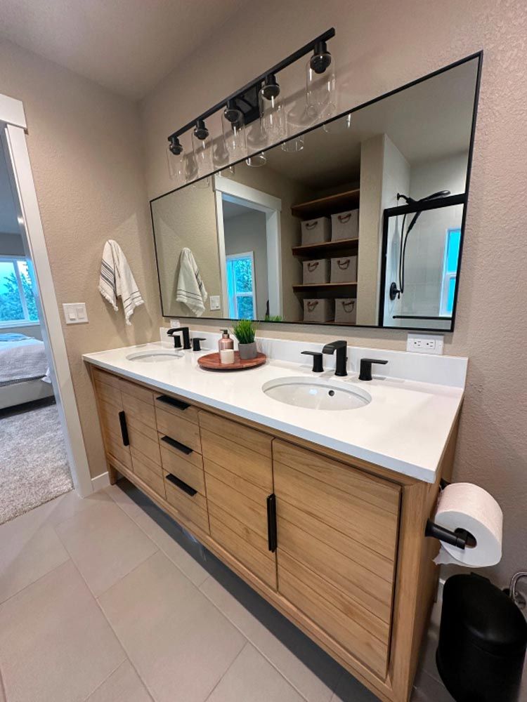 A bathroom with two sinks and a large mirror.