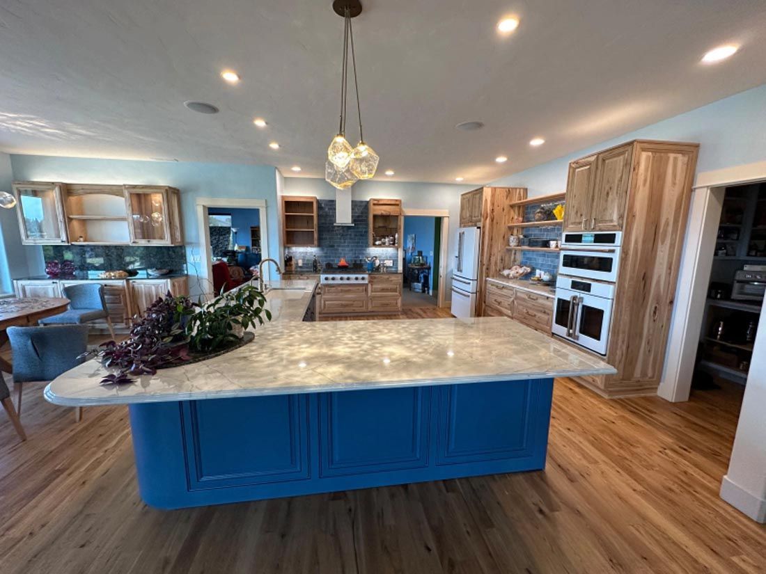 A kitchen with a large blue island in the middle of it.