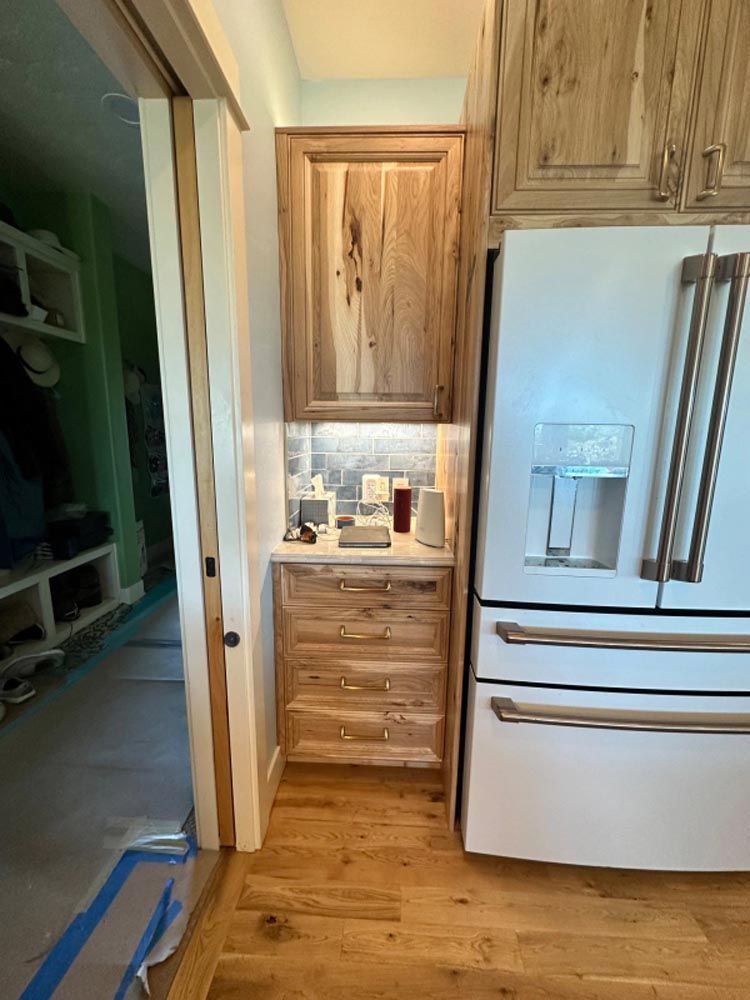 A kitchen with wooden cabinets and a white refrigerator.