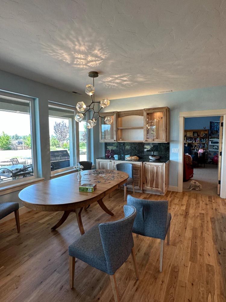 A dining room with a table and chairs and a chandelier hanging from the ceiling.