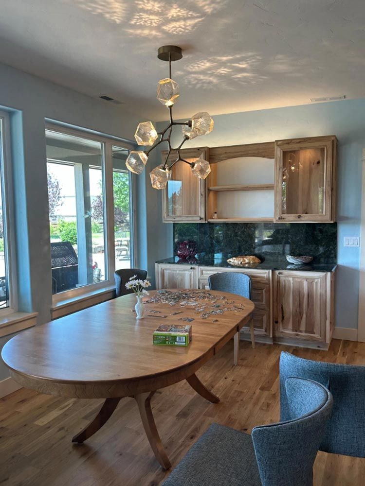 A dining room with a table and chairs and a chandelier hanging from the ceiling.