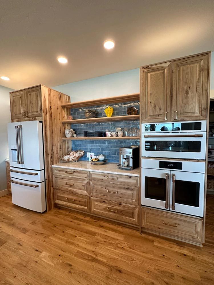 A kitchen with wooden cabinets , white appliances , and hardwood floors.