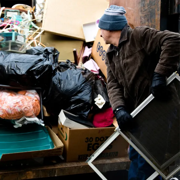 Hall's Hauling - A man is pushing a cart with a box that says 30 dozen eggs on it