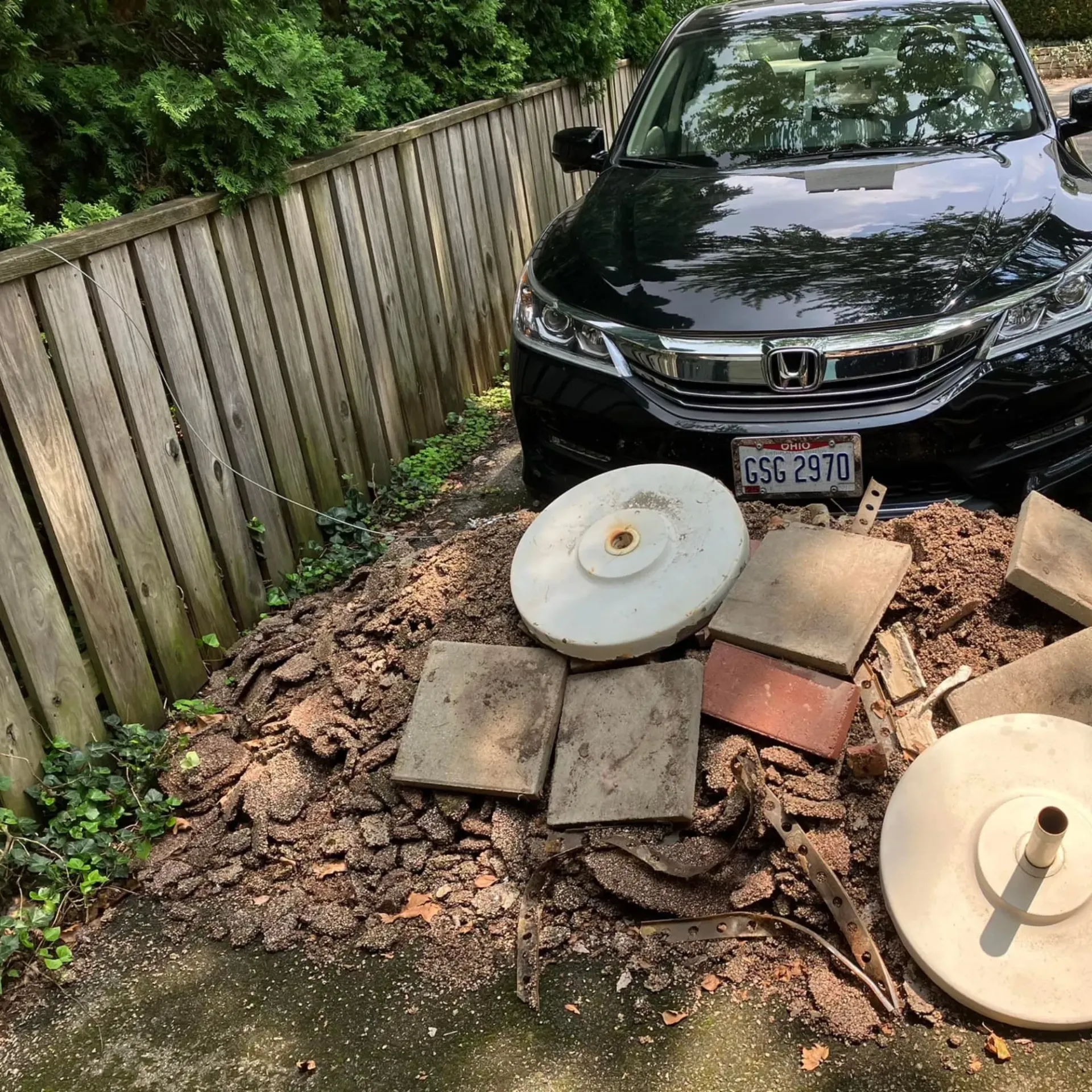 Hall's Hauling -A black honda accord is parked in a driveway next to a wooden fence.