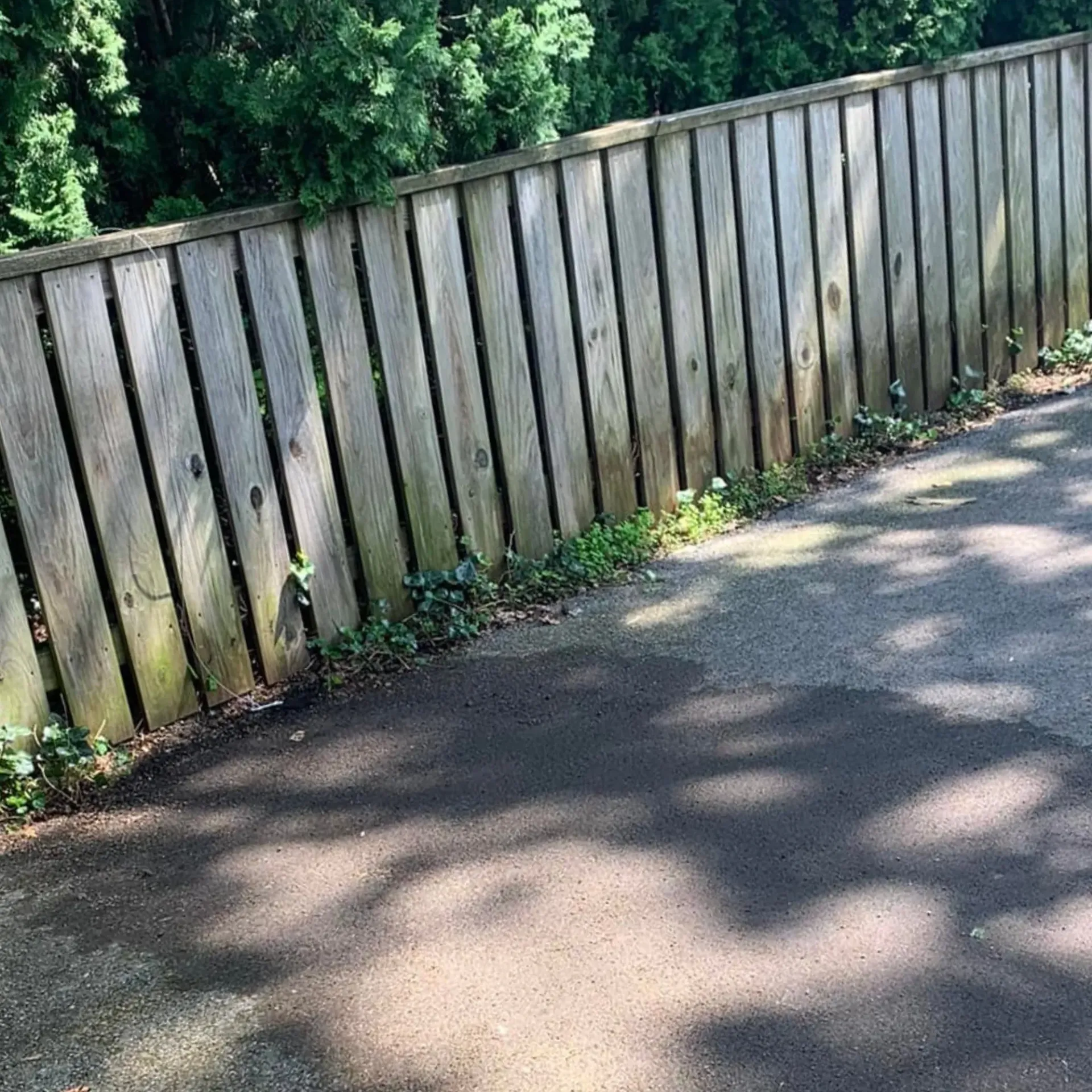 Hall's Hauling -A wooden fence is sitting on the side of a road.