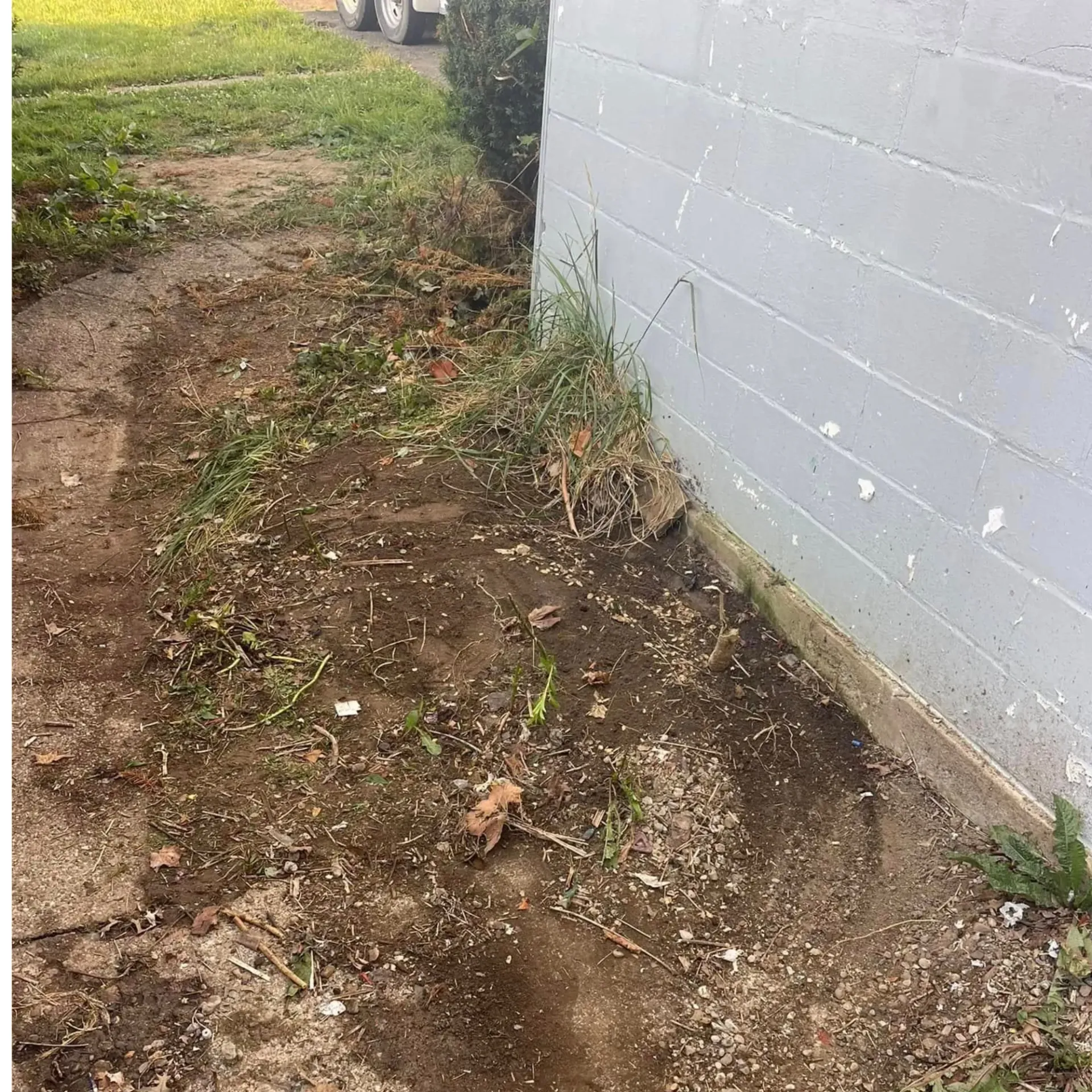 Hall’s Hauling - A dirt path leading to a white brick building.