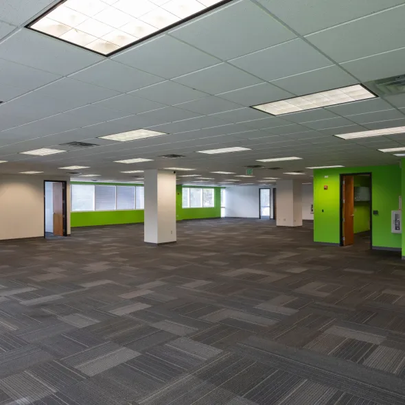 Hall's Hauling -A large empty office with a green wall