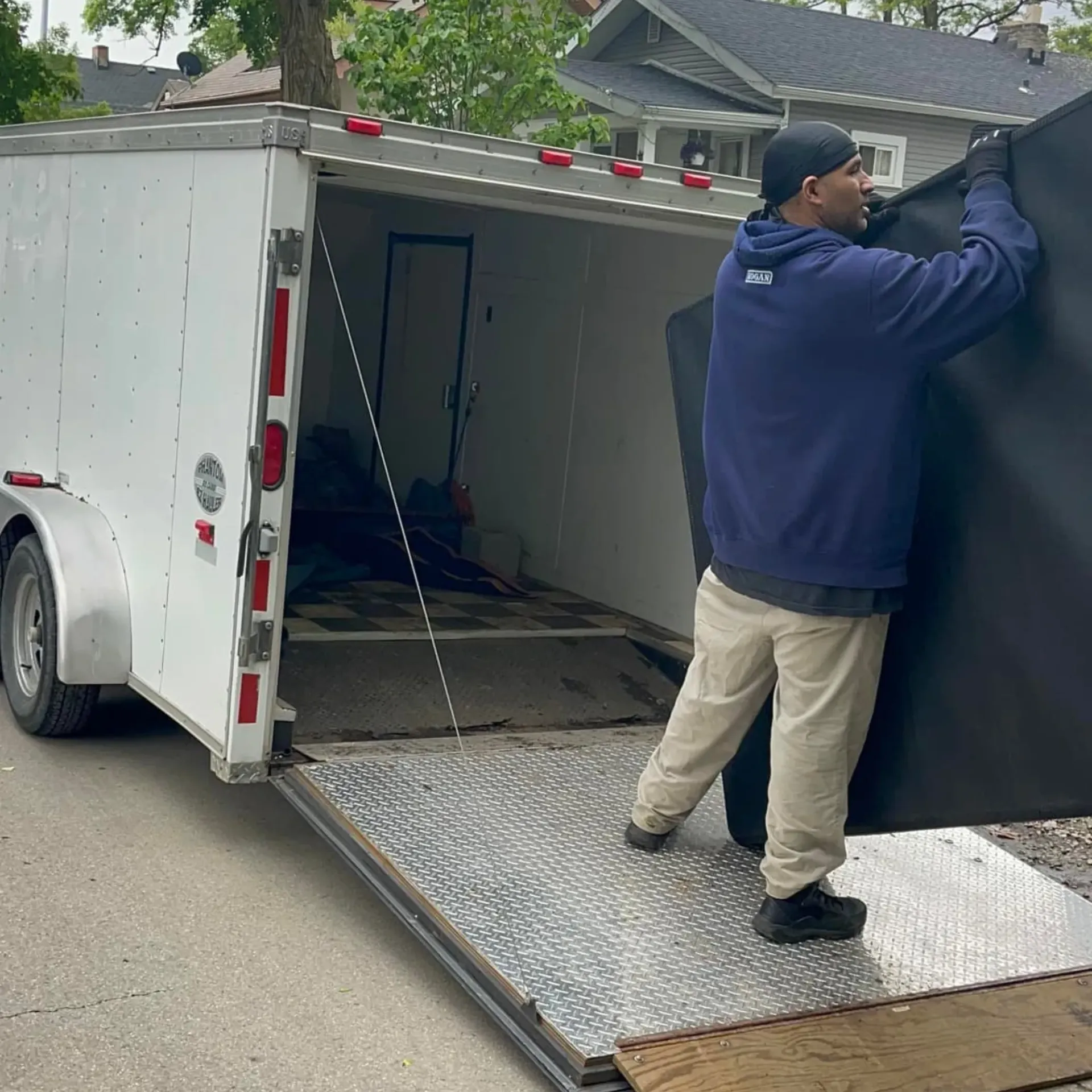 Hall’s Hauling - A man in a blue hoodie is loading a trailer