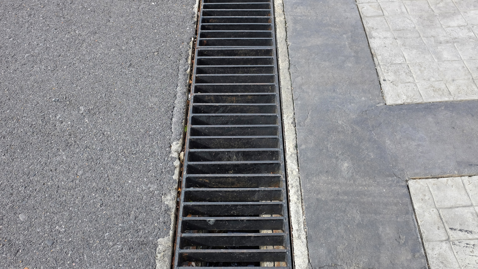 A close up of a manhole cover on the side of a road.