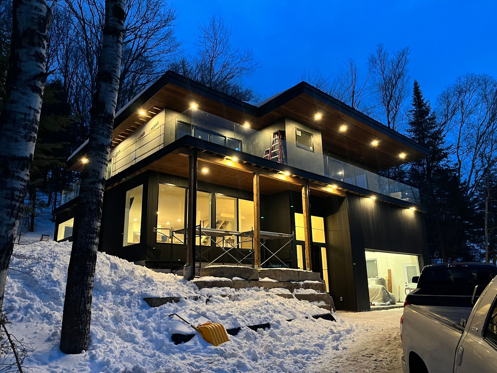 A large house is sitting on top of a snow covered hill.