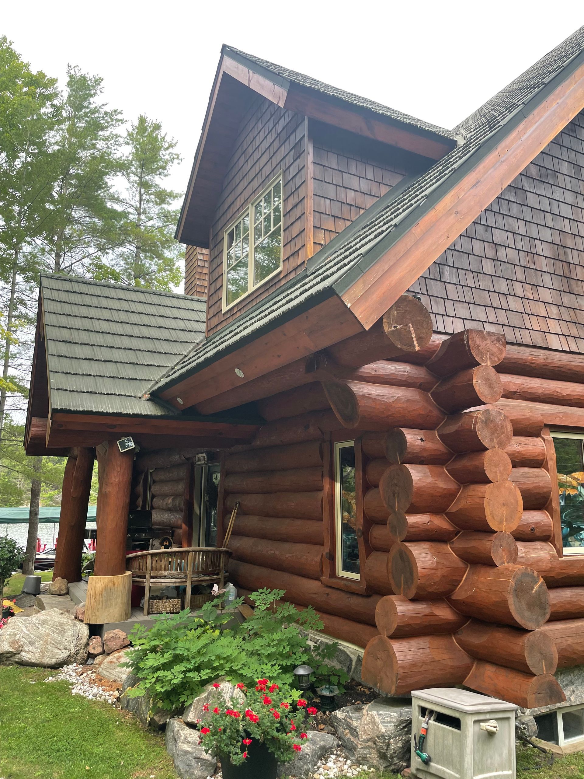 A large log cabin with a lot of windows and a roof.
