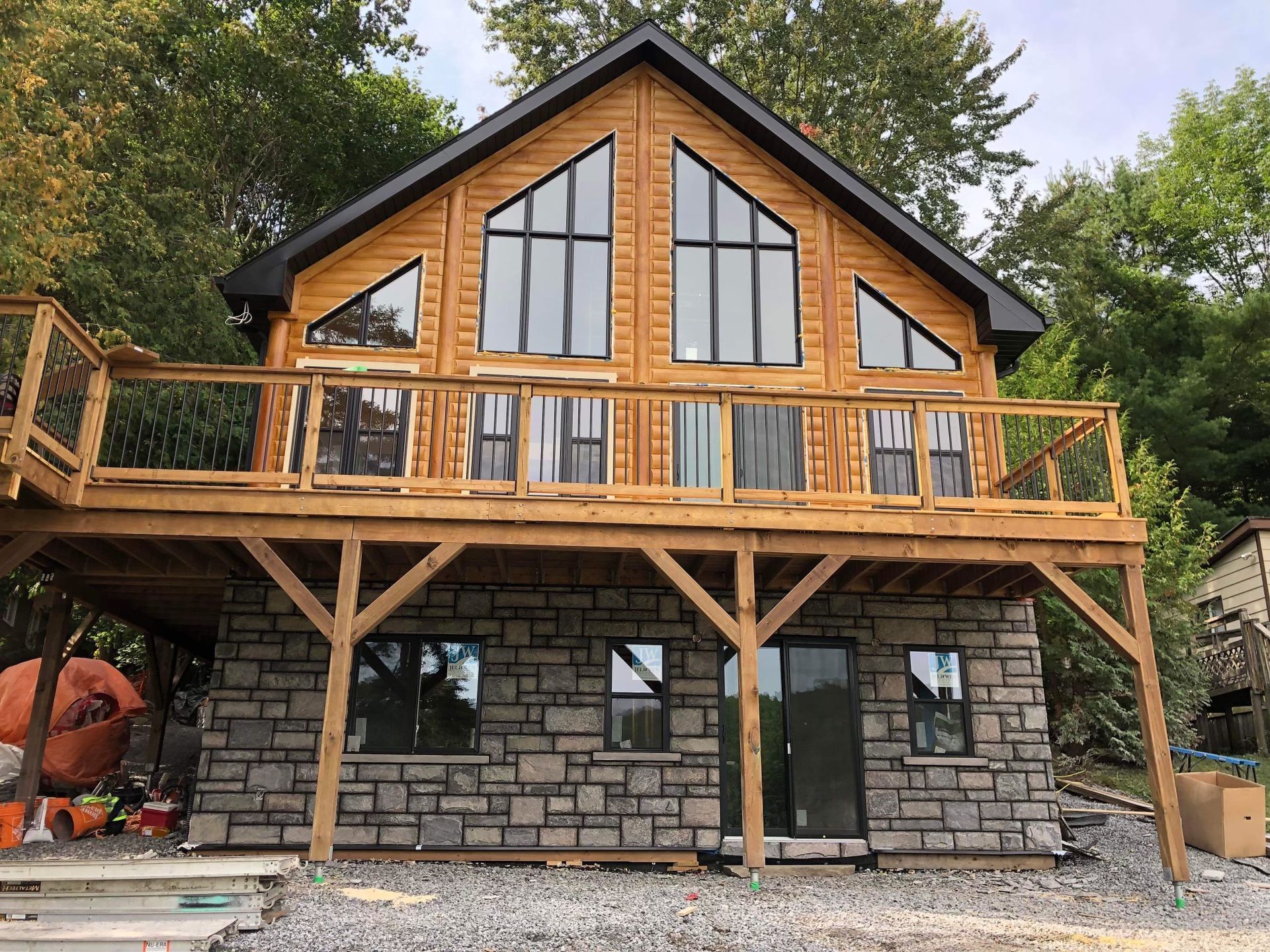 A large wooden house with a large deck on top of it.