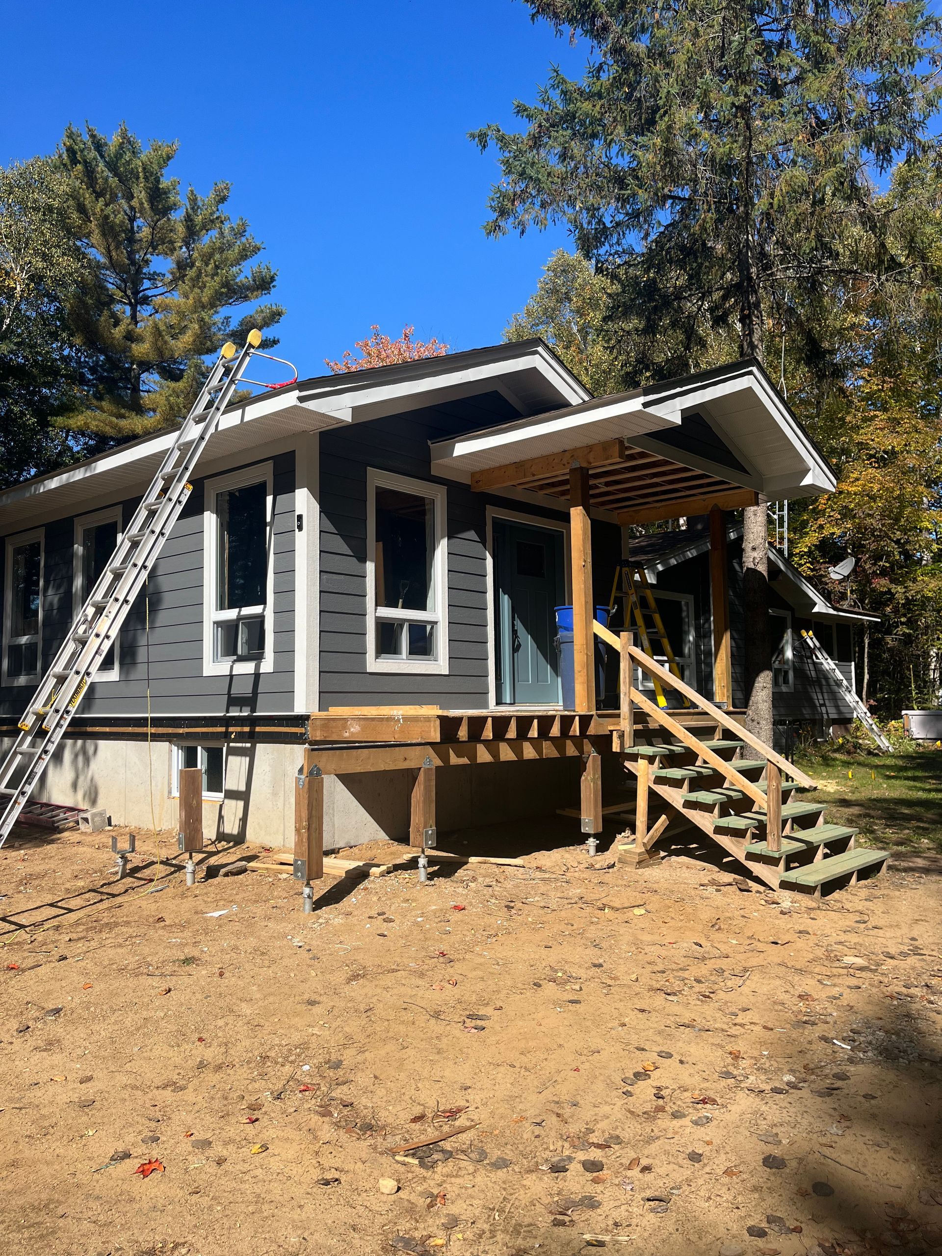 A small house with stairs and a ladder in front of it.