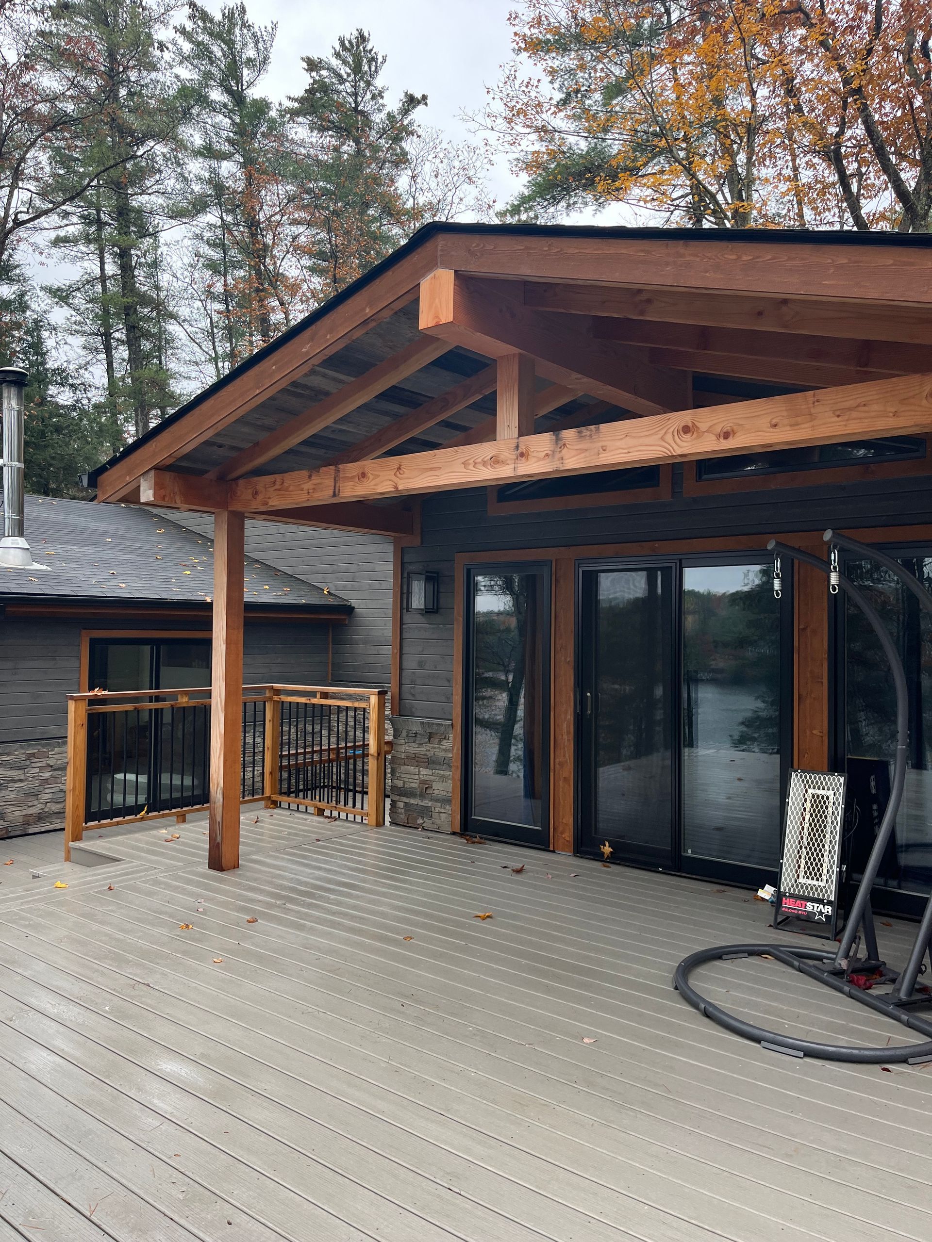 A large house with a wooden deck and a covered porch.