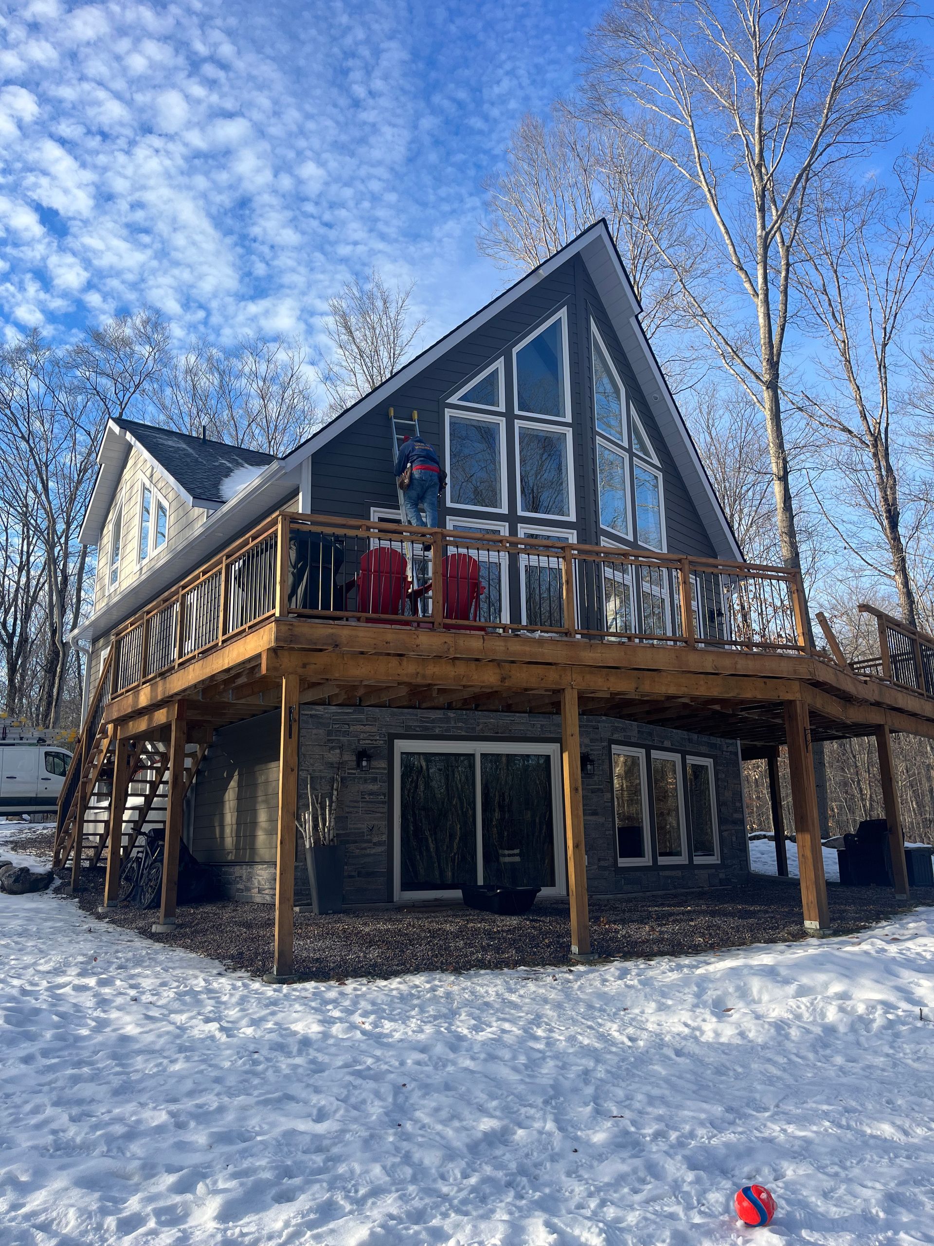 A large house with a large deck in the snow.
