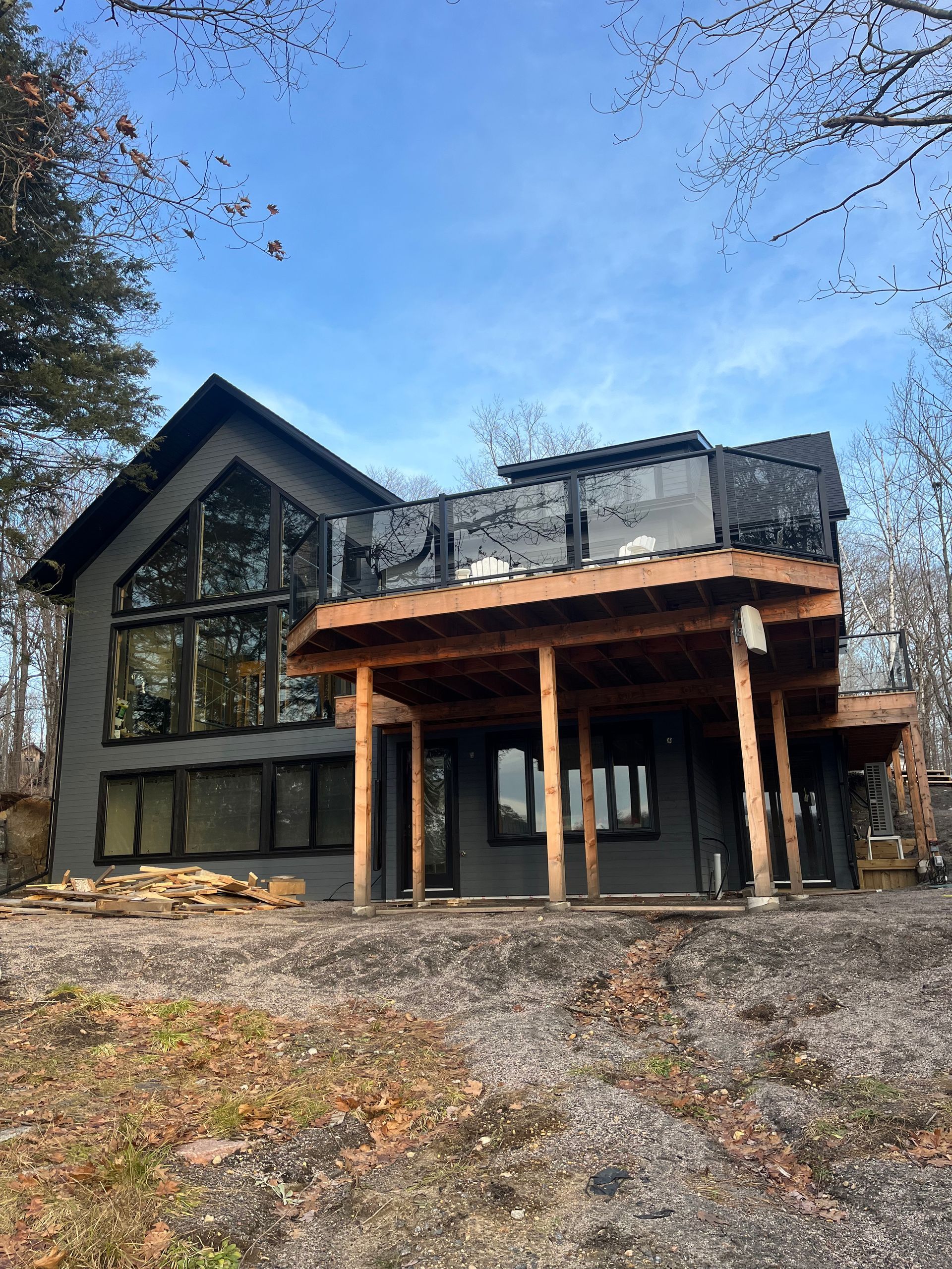 A large house with a large deck is sitting on top of a hill.