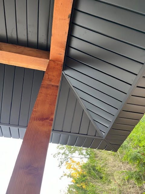 A person is installing siding on the side of a house.