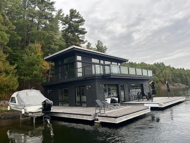 A man is installing a gutter on the side of a house.
