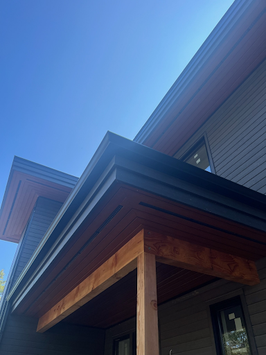 A house with a porch and a blue sky in the background.