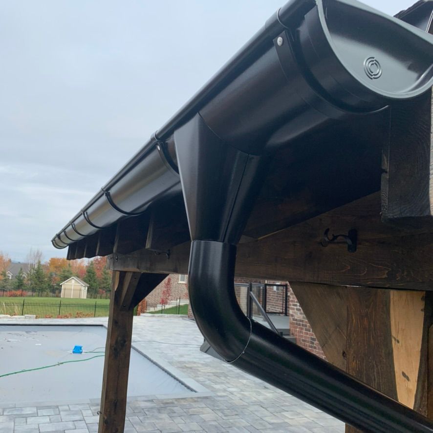 A brown gutter is attached to the side of a house.