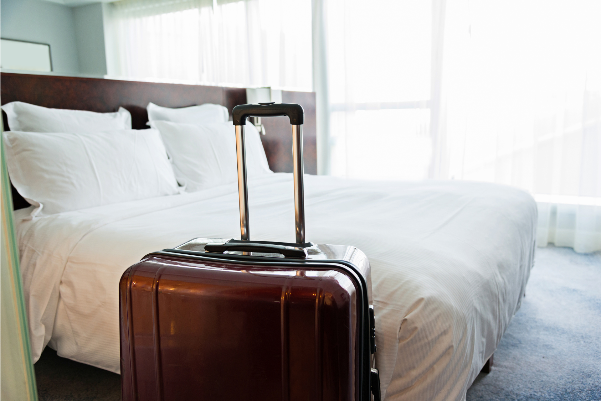 a suitcase is sitting on a bed in a hotel room .
