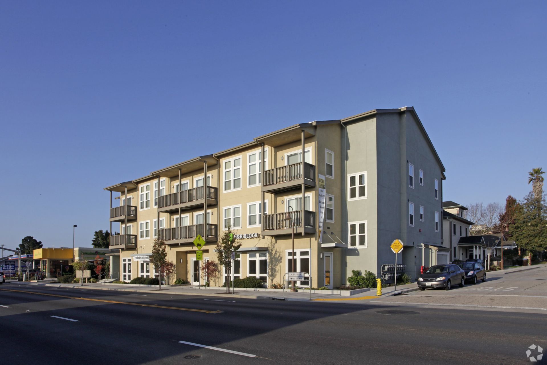 A large apartment building with cars parked in front of it