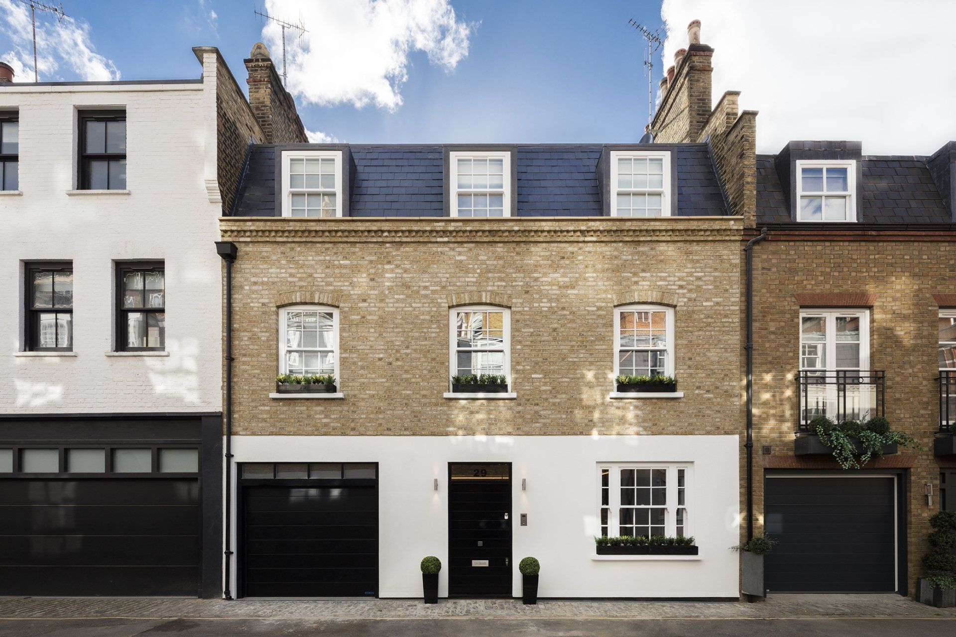 A row of brick houses with black garage doors