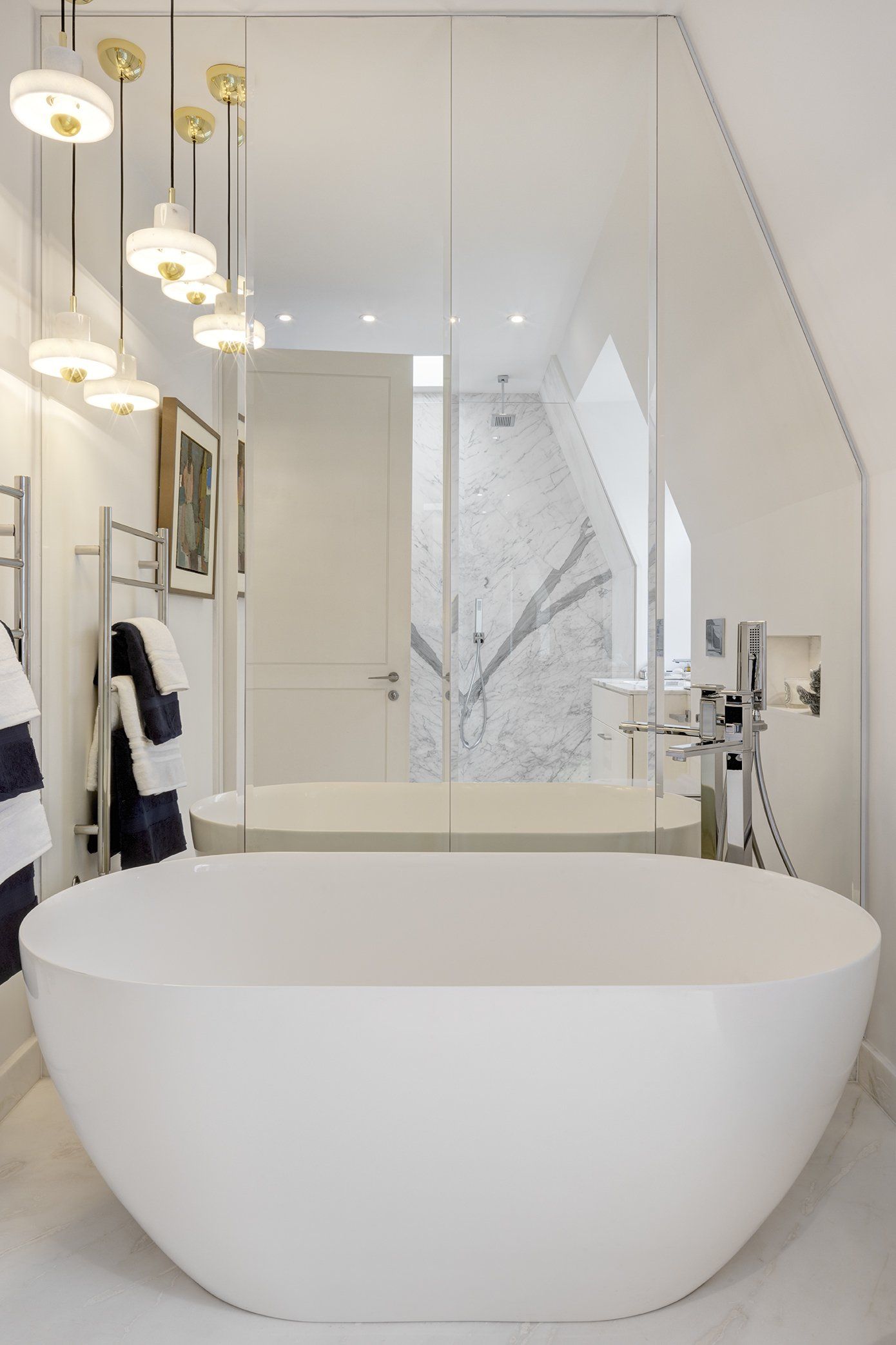 A bathroom with a white tub and a large mirror
