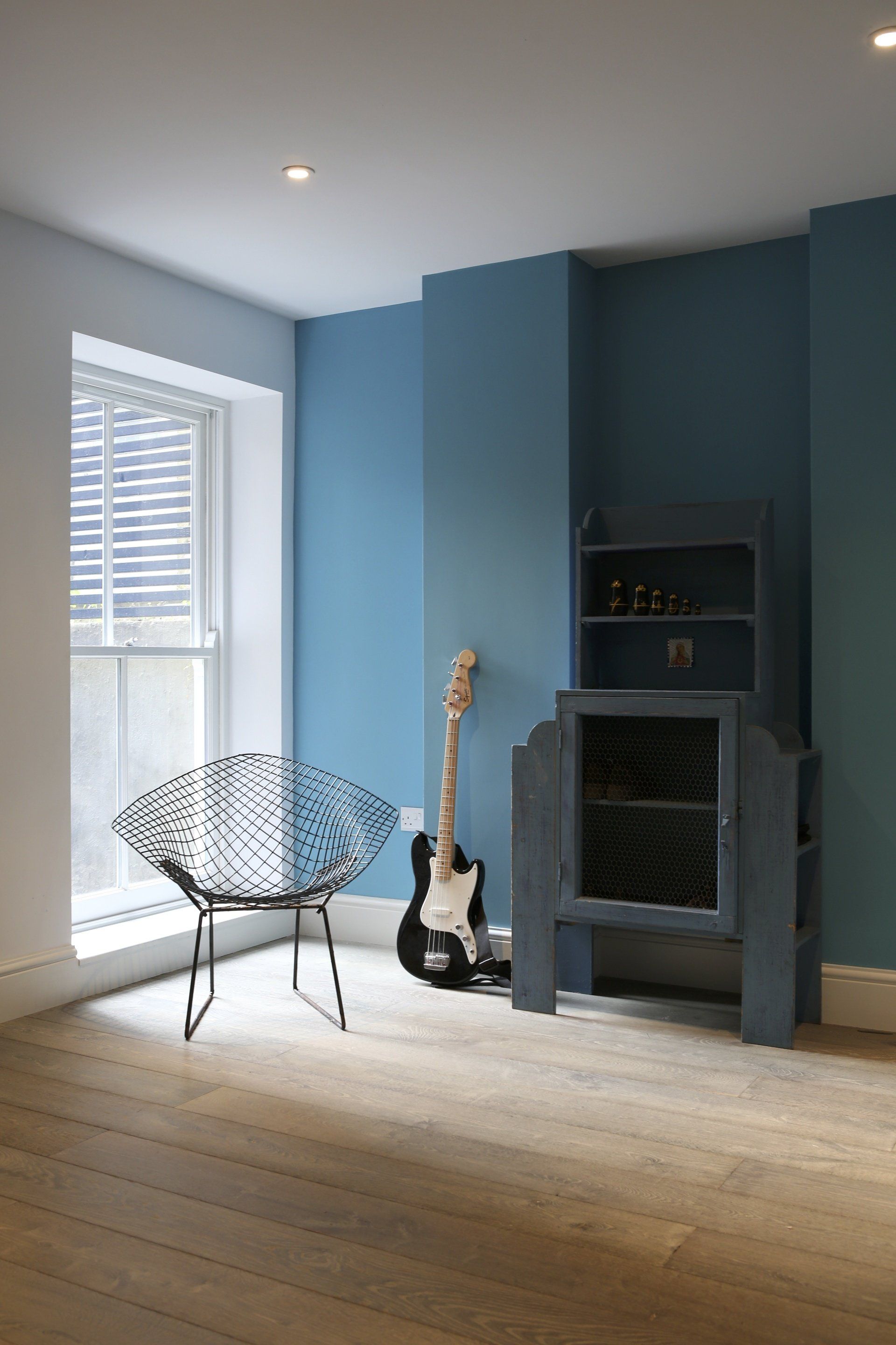 A room with a chair and a guitar on the floor