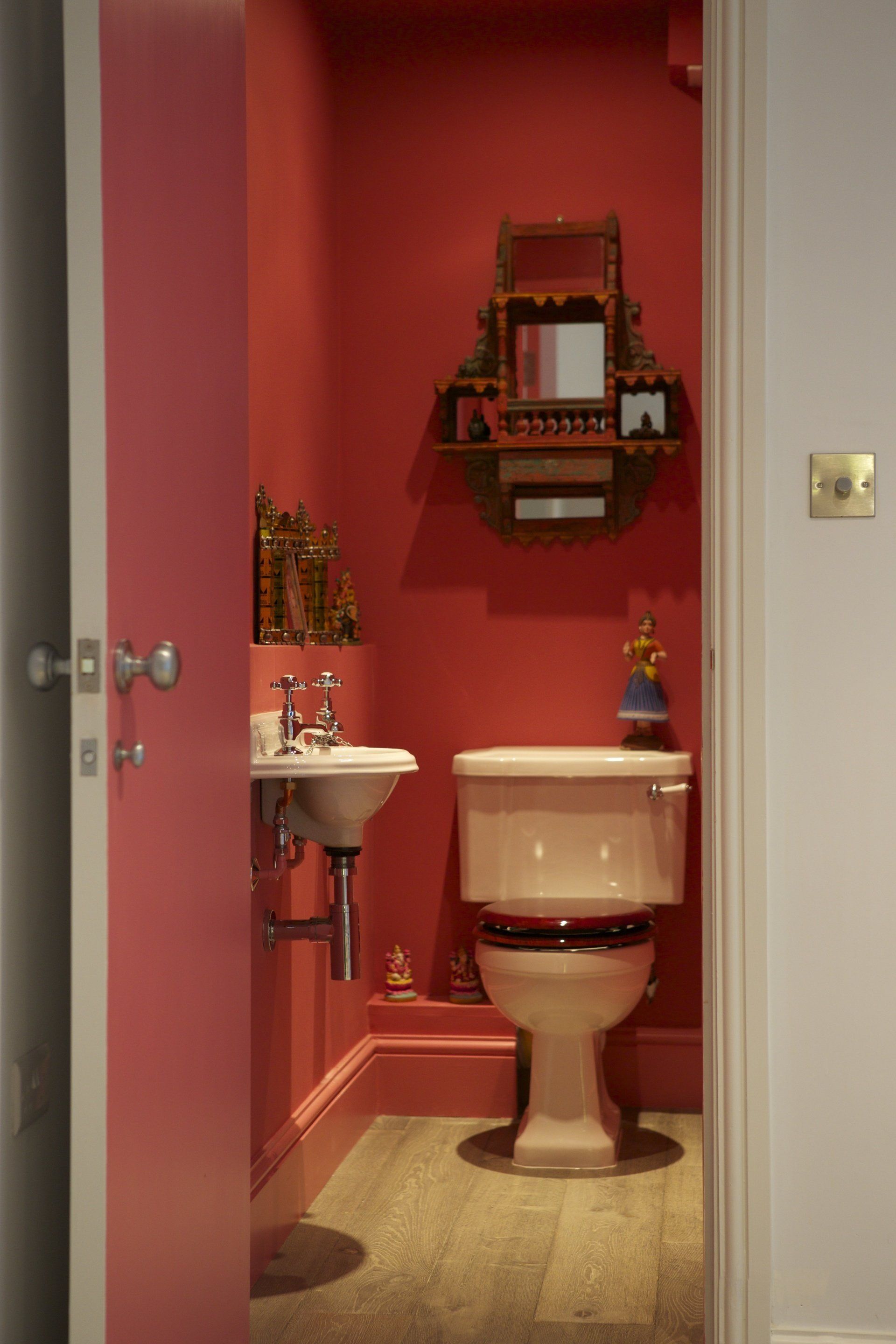 A bathroom with red walls and a toilet and sink
