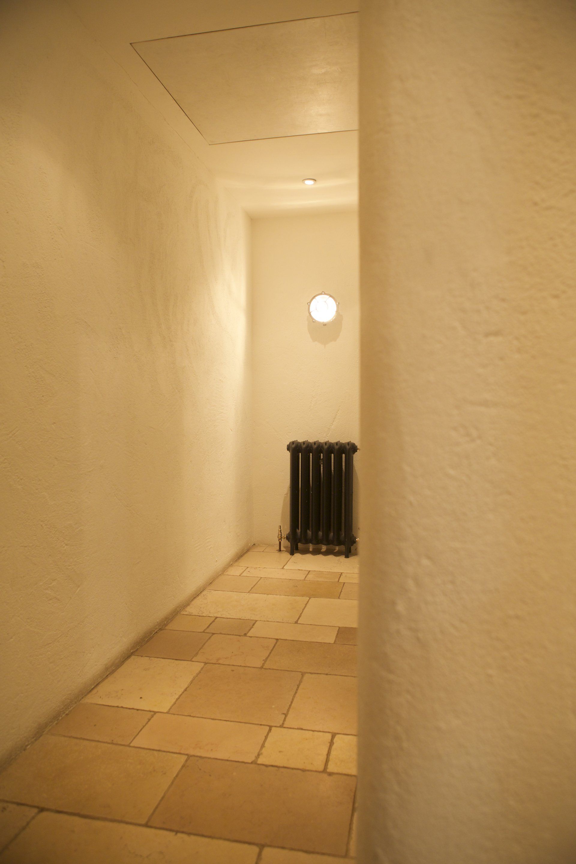 A narrow hallway with a radiator in the corner