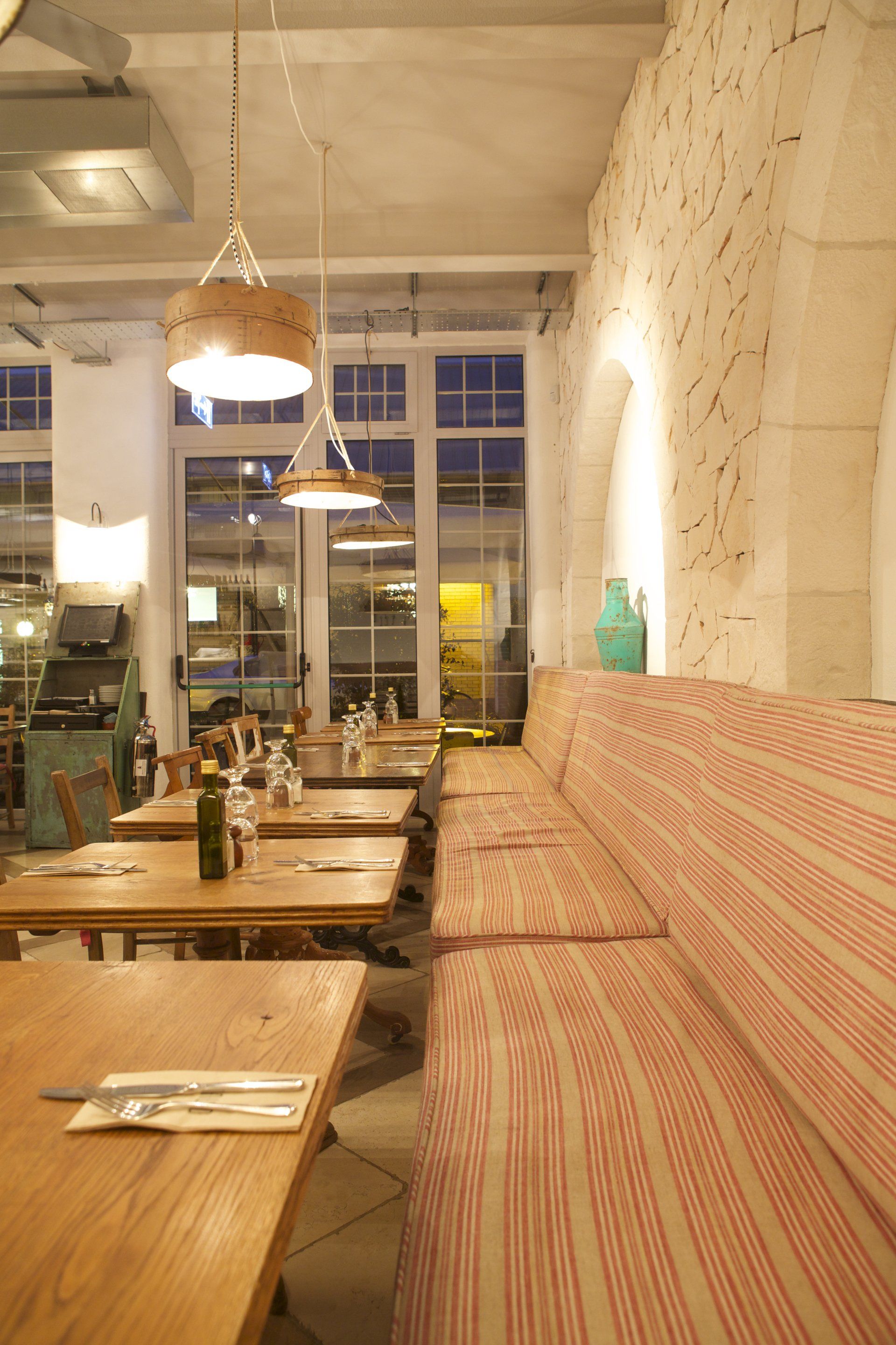 A restaurant with tables and a red and white striped couch