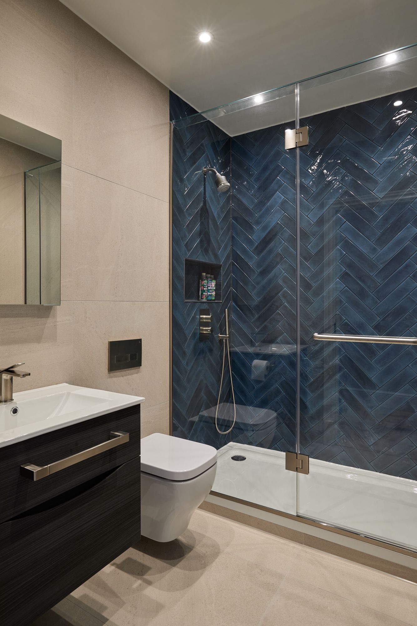 A bathroom with blue tiles and a walk in shower