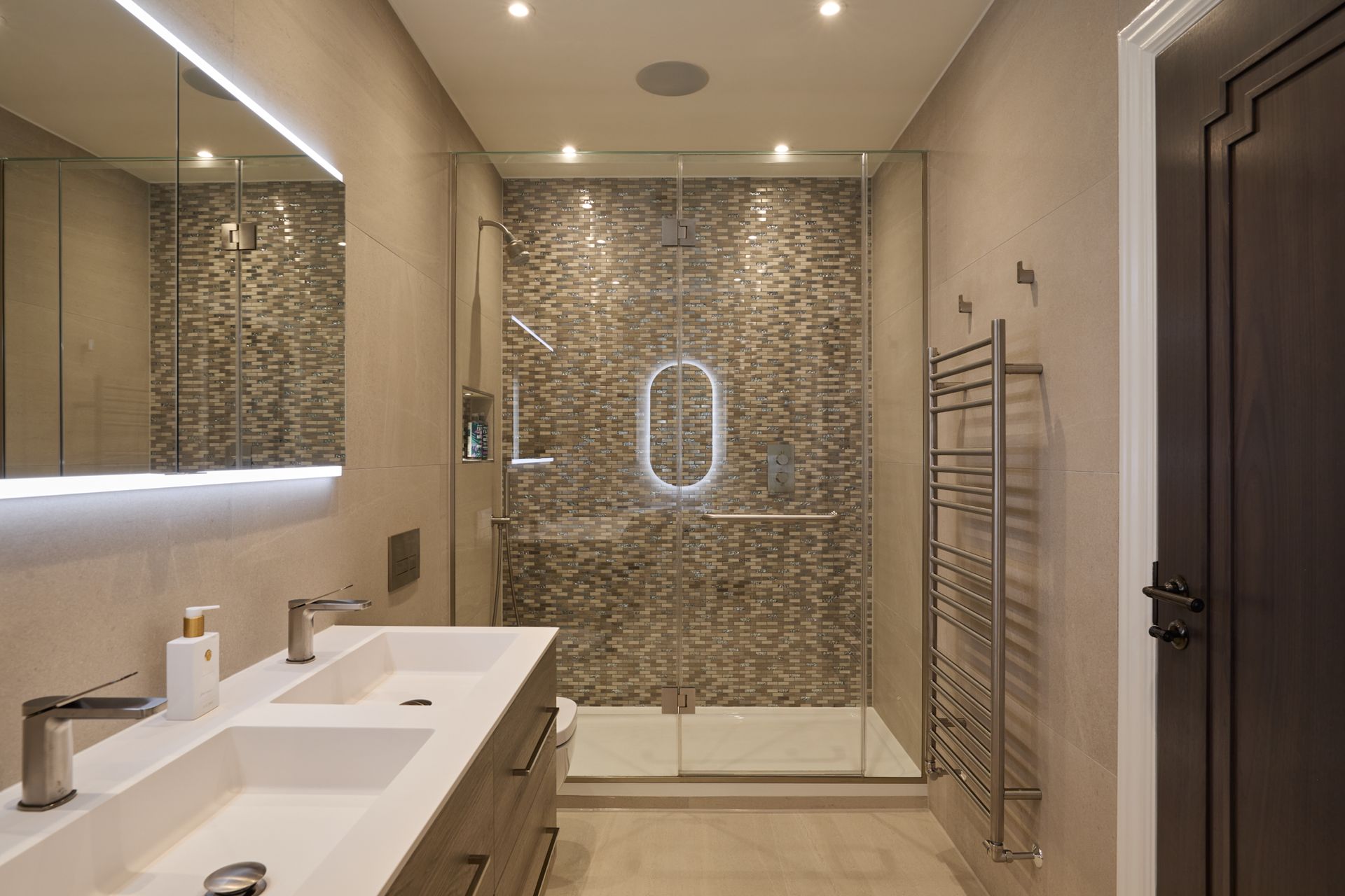 A bathroom with two sinks and a walk in shower