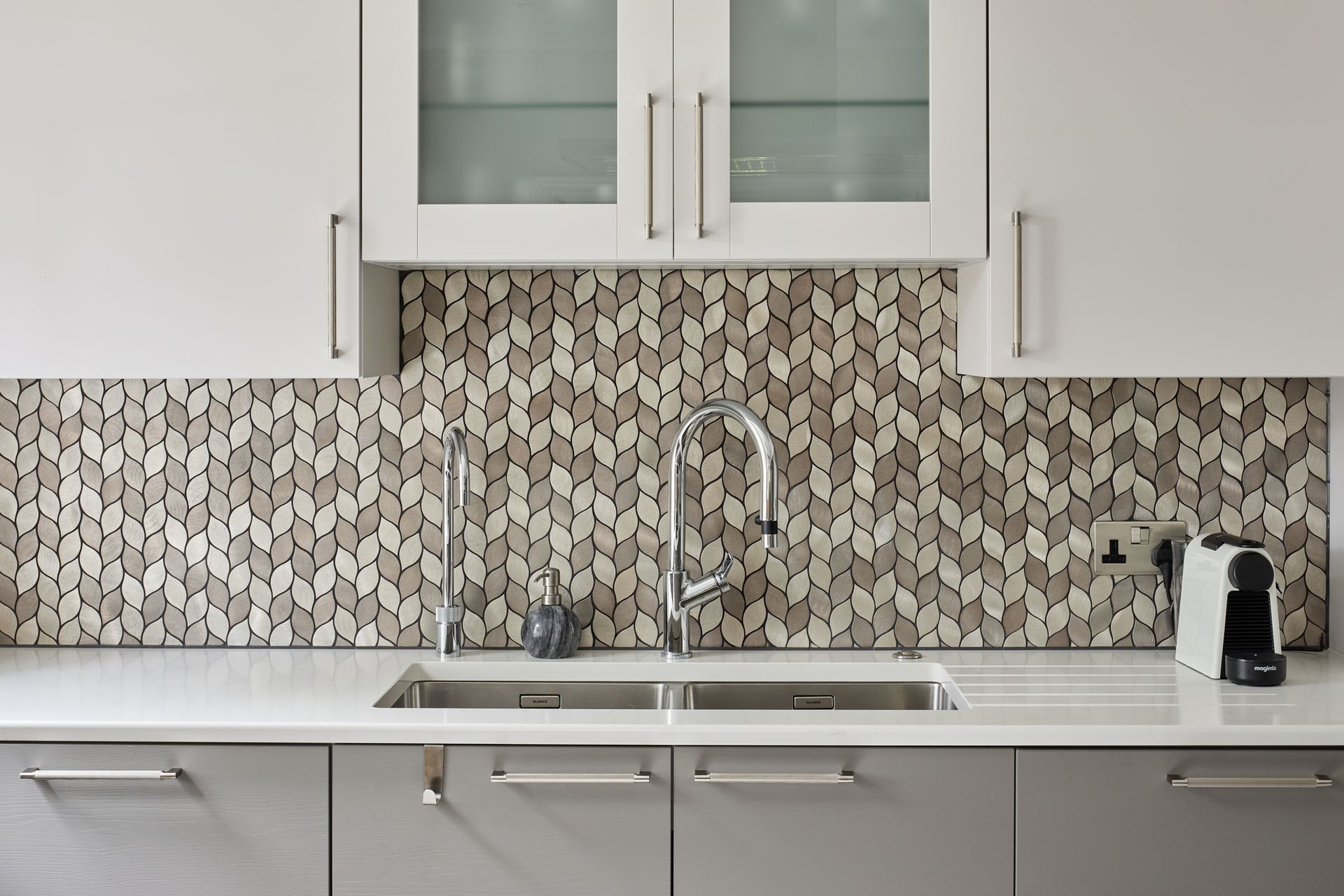 A kitchen with white cabinets and a stainless steel sink