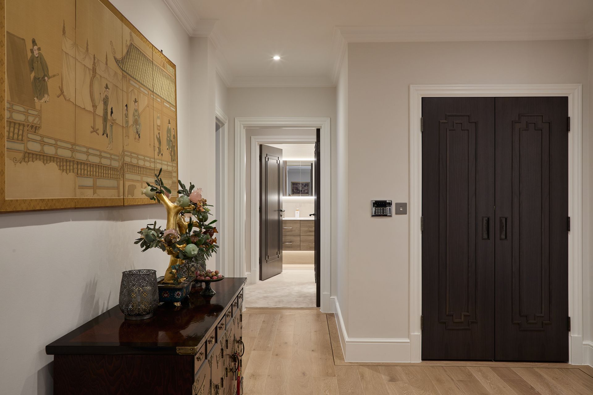 A hallway with a dresser and a painting on the wall