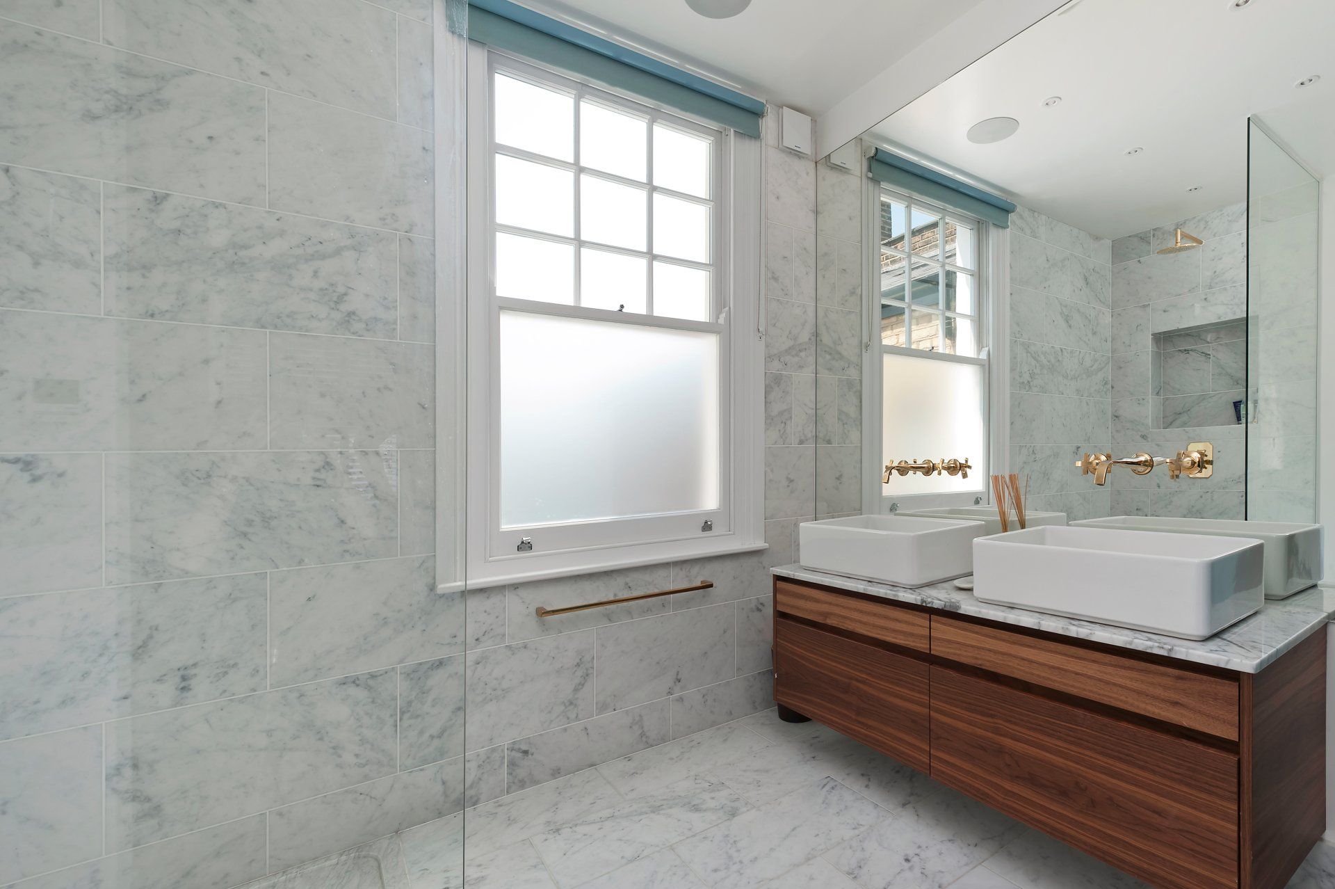 A bathroom with two sinks and a large mirror