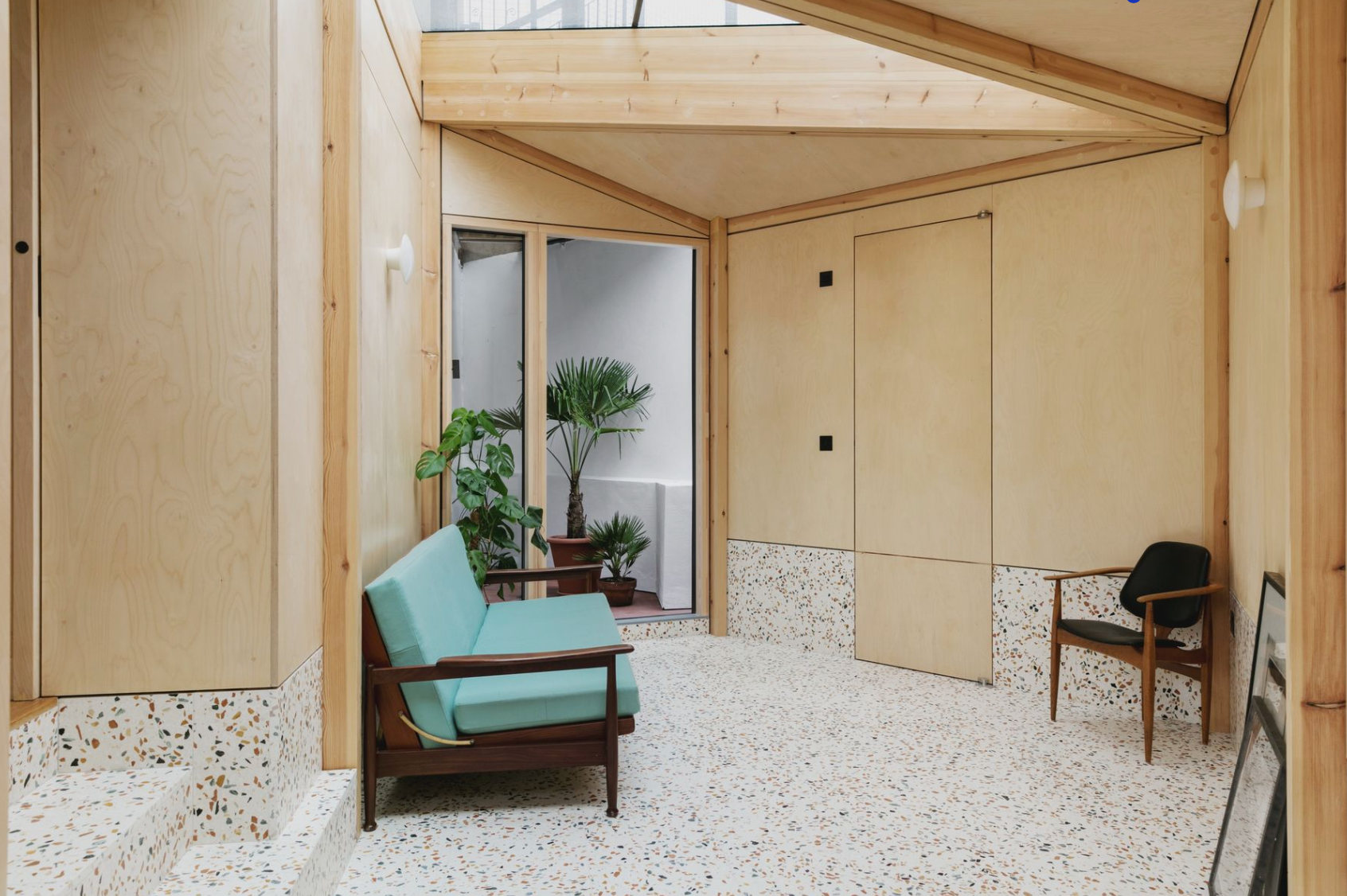 A living room with a blue couch and two chairs